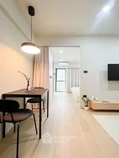 Modern open-plan living room with dining area and cozy bedroom view