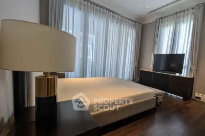 Luxurious bedroom with elegant decor and large windows offering natural light