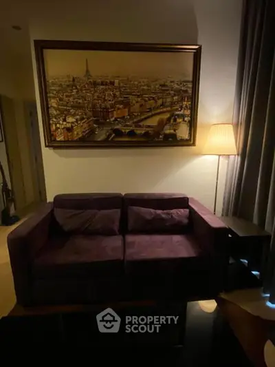 Cozy living room with plush purple sofa and elegant cityscape artwork.