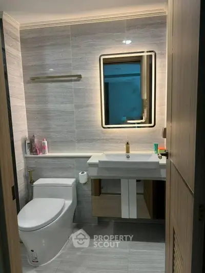 Modern bathroom with sleek fixtures and illuminated mirror