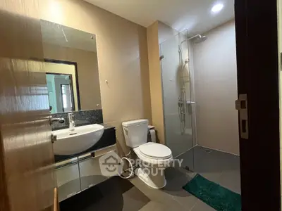 Modern bathroom with glass shower and sleek fixtures in a contemporary home.