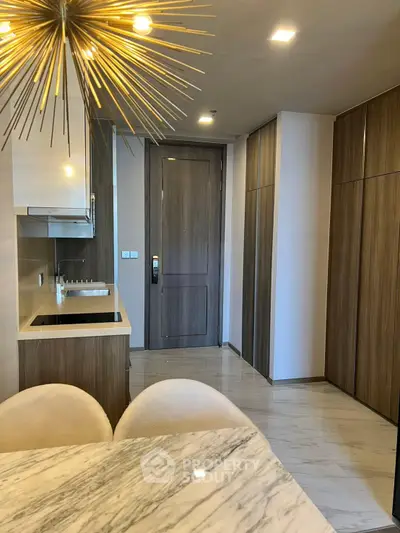 Modern kitchen with sleek cabinetry and marble dining table in a stylish apartment.