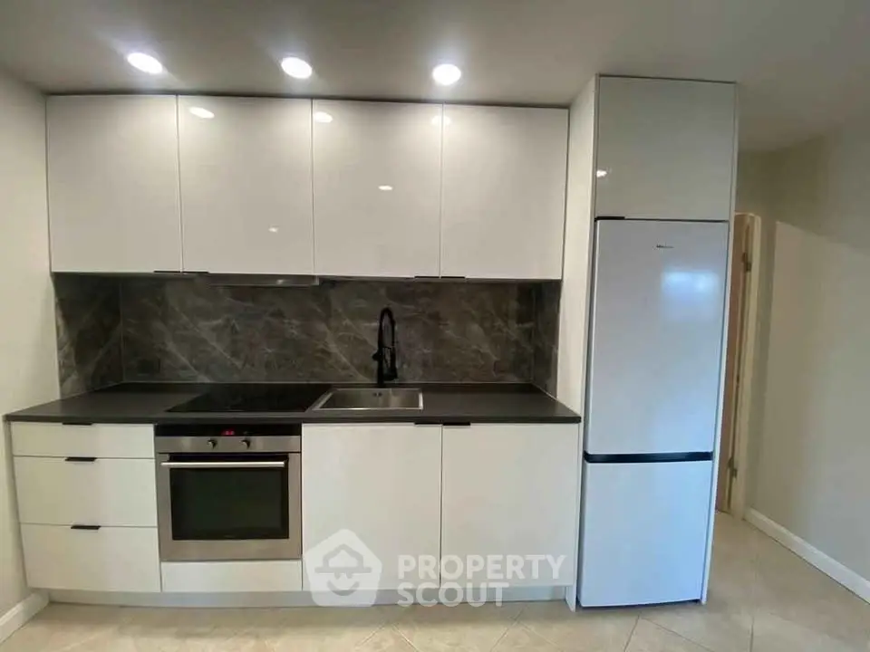 Modern kitchen with sleek white cabinets and built-in appliances