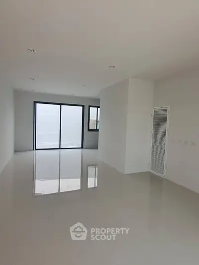 Spacious modern living room with large windows and glossy tiled floors