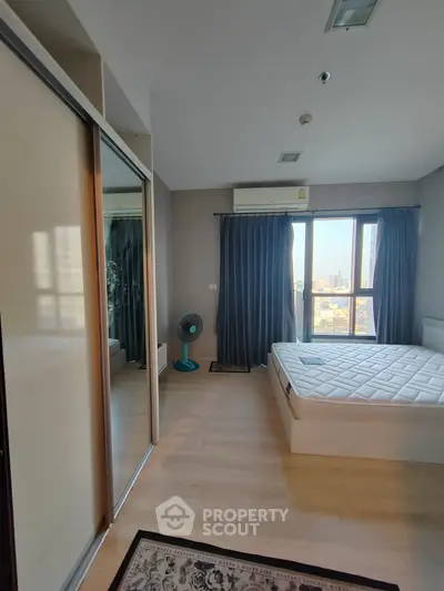 Spacious bedroom with city view, modern furnishings, and ample natural light.