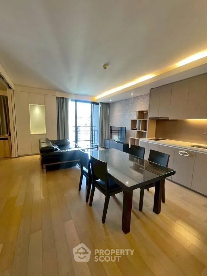 Spacious modern living room with open kitchen and large windows in luxury apartment.