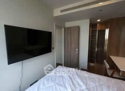 Modern bedroom with wall-mounted TV and stylish wooden furniture