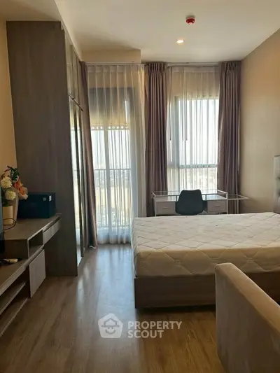 Modern bedroom with large windows and stylish furnishings in a high-rise apartment.