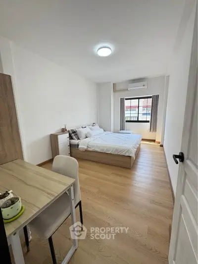 Spacious bedroom with modern furnishings and natural light in a stylish apartment.