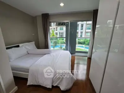 Spacious bedroom with pool view in modern apartment, featuring elegant decor and natural light.