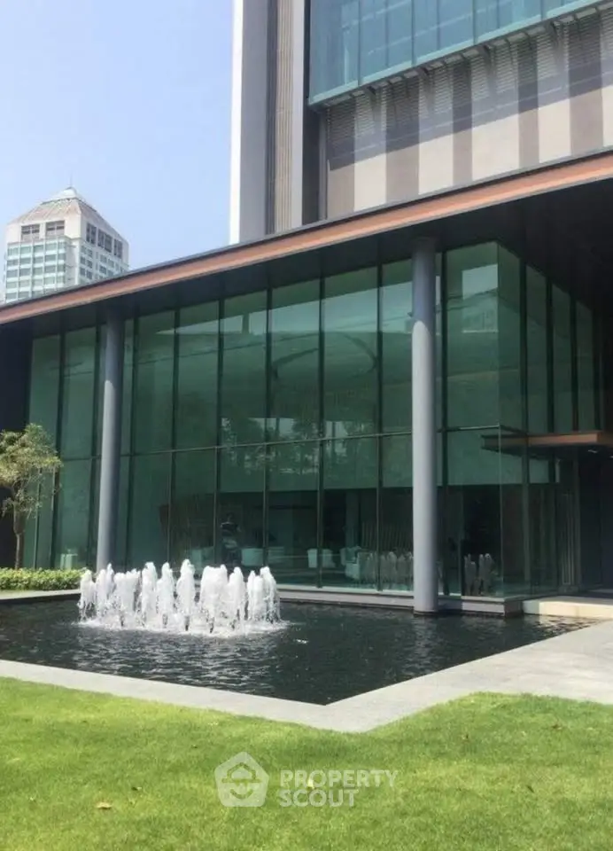 Modern building exterior with glass facade and elegant water fountain