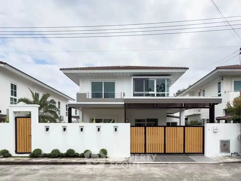 Modern two-story house with sleek design and spacious driveway in a suburban neighborhood.