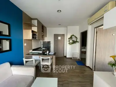 Modern living room with open kitchen, stylish decor, and wooden flooring in a cozy apartment.