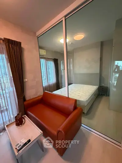 Modern apartment with glass partition, cozy living area, and stylish bedroom.