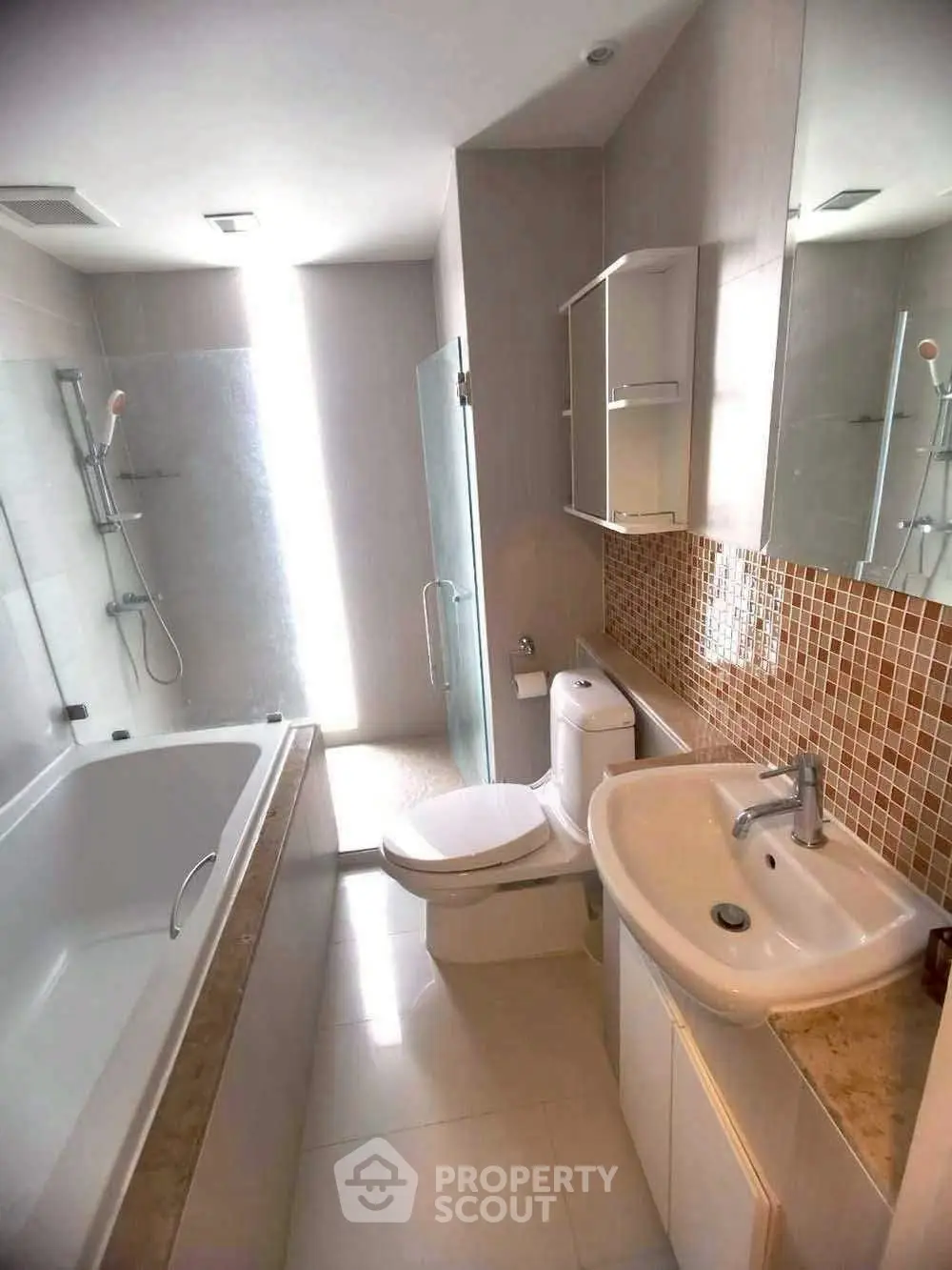 Modern bathroom with bathtub and glass shower enclosure, featuring sleek fixtures and mosaic tile accents.
