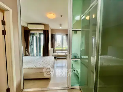 Modern bedroom with large windows and city view, featuring sleek furniture and ample natural light.