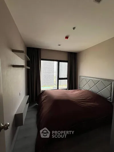 Cozy bedroom with large window and modern decor in urban apartment