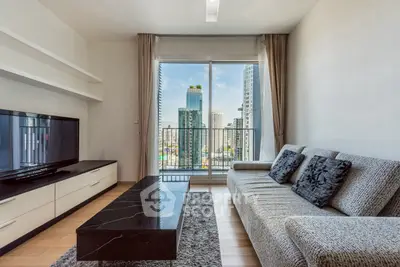 Modern living room with city view, stylish sofa, and sleek TV setup.