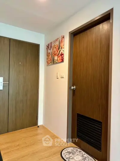 Modern apartment entrance with wooden doors and floral wall art