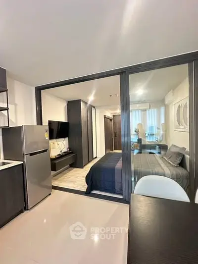 Modern studio apartment with sleek design and open layout, featuring a cozy bedroom and contemporary kitchen.
