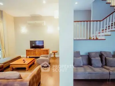 Spacious living room with modern furniture and elegant staircase