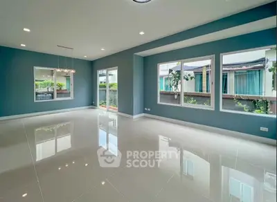 Spacious modern living room with large windows and glossy tile flooring, perfect for natural light and contemporary living.