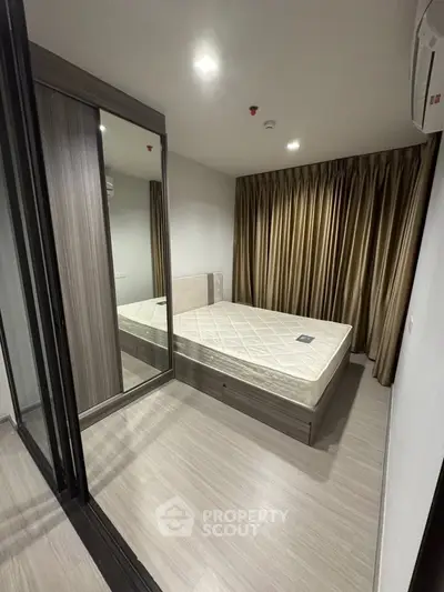 Modern bedroom with mirrored wardrobe and elegant curtains in a stylish apartment.