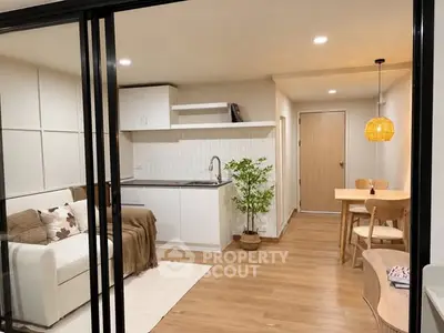 Modern open-plan living room and kitchen with stylish decor and warm lighting