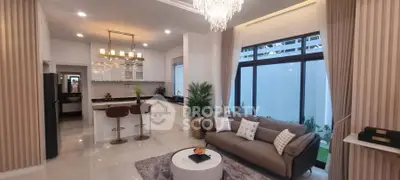 Luxurious modern living room with elegant chandelier and open kitchen layout, perfect for stylish living.
