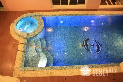 Luxurious indoor swimming pool with elegant mosaic design and ambient lighting