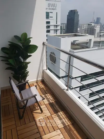 Charming balcony with wooden flooring and city view, perfect for relaxation.