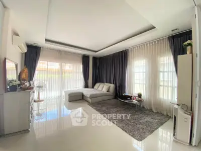 Spacious living room with modern decor and large windows for natural light.