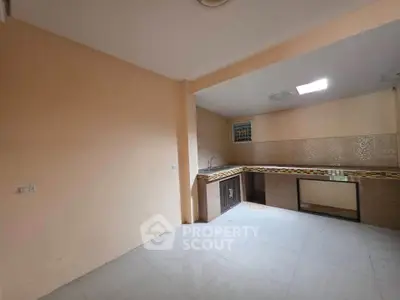 Spacious kitchen with open layout and tiled countertops in modern apartment.
