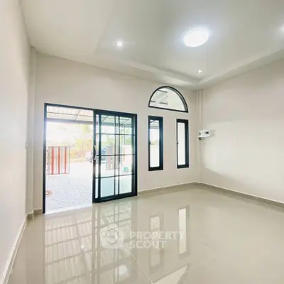 Spacious empty room with large windows and glossy tiled floor, perfect for customization.