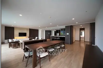 Spacious modern living room with elegant dining area and sleek wooden flooring.