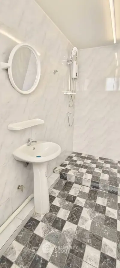 Modern bathroom with marble tiles and round mirror