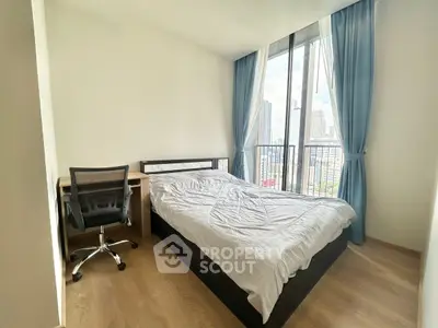 Modern bedroom with city view, featuring a cozy bed and workspace, ideal for urban living.