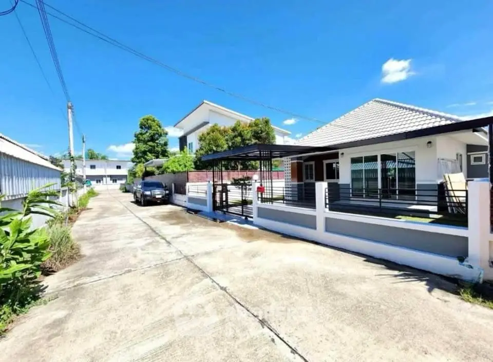 Charming single-story home with spacious driveway and modern exterior design in a serene neighborhood.