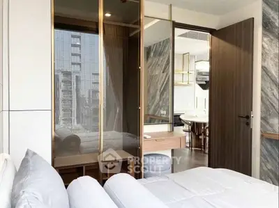 Luxurious bedroom with modern glass partition and city view, featuring elegant decor and stylish furnishings.