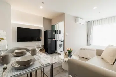 Modern studio apartment with open layout, featuring a cozy living area, dining space, and compact kitchen.