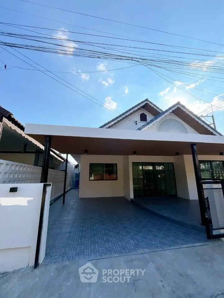 Charming single-story house with spacious carport and modern exterior design under clear blue skies.