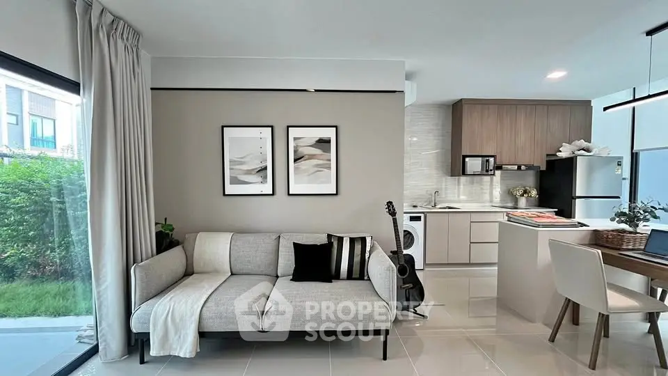 Modern open-layout living room and kitchen with stylish decor and natural light.