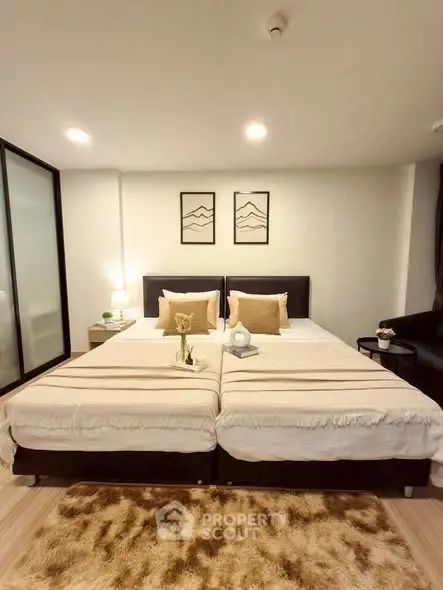 Modern bedroom with twin beds and stylish decor in a cozy apartment.