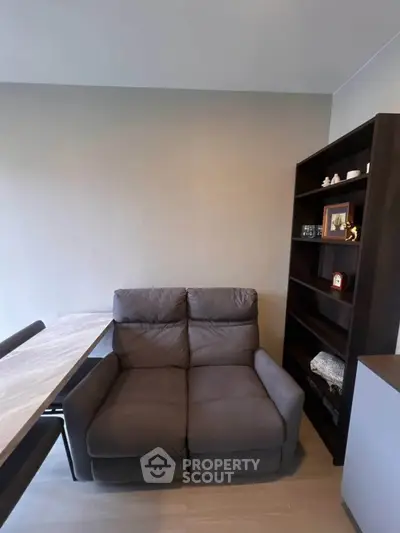Cozy living room with plush sofa and modern bookshelf, perfect for relaxation and reading.