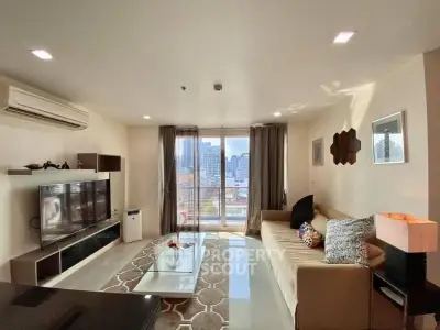 Spacious living room with city view, modern decor, and ample natural light.