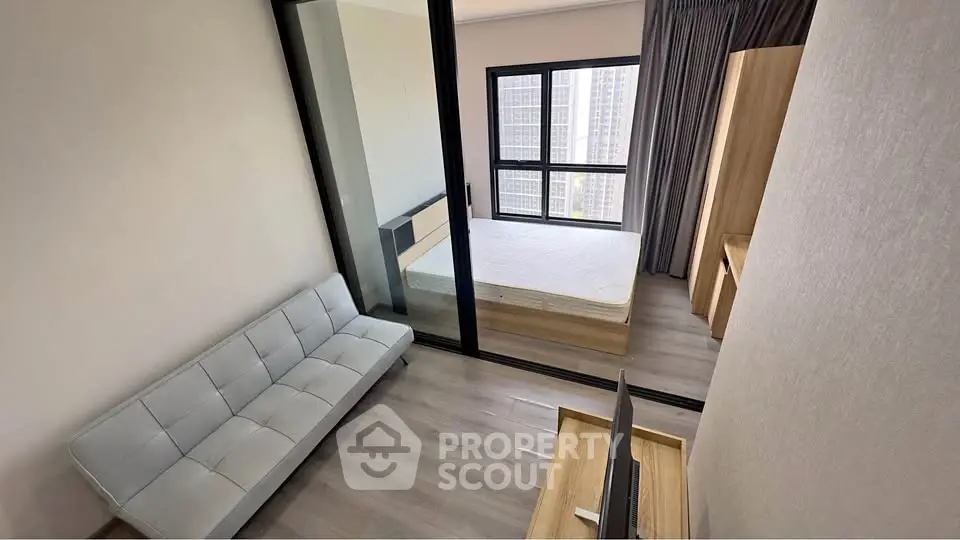 Modern apartment with glass partition, cozy bedroom, and stylish living area.