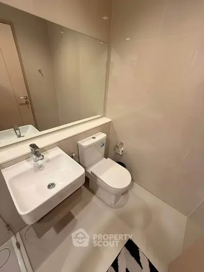 Modern bathroom with sleek fixtures and large mirror in a contemporary apartment.