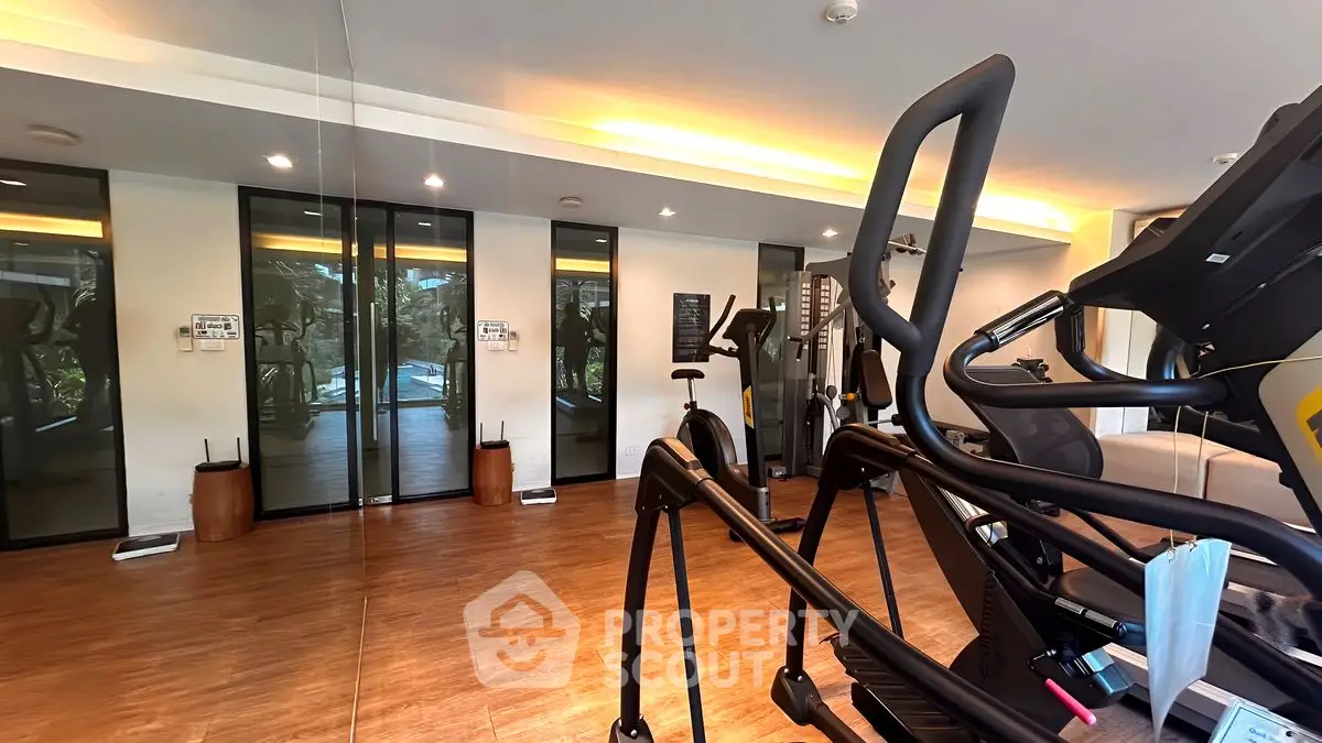 Modern gym with state-of-the-art fitness equipment and mirrored walls in luxury real estate property.