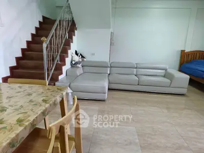 Spacious living room with modern sofa and wooden staircase