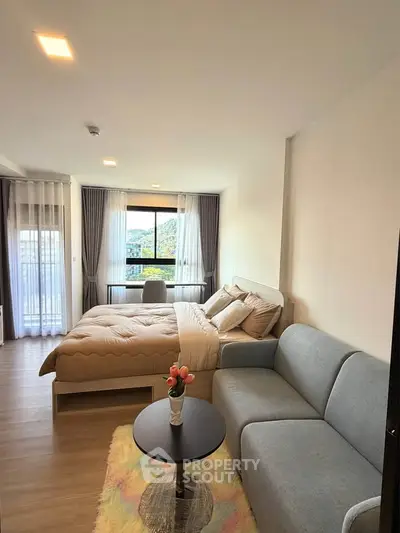Modern studio apartment with cozy living area and scenic window view